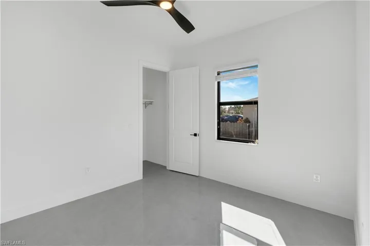 Unfurnished room with a ceiling fan and baseboards