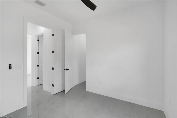 Unfurnished room with ceiling fan and light tile patterned floors
