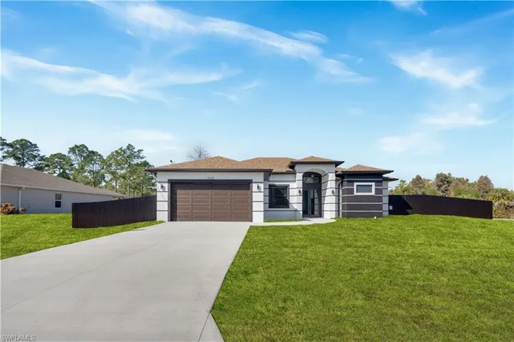Prairie-style home featuring concrete driveway, an attached garage, a shingled roof, and stucco siding