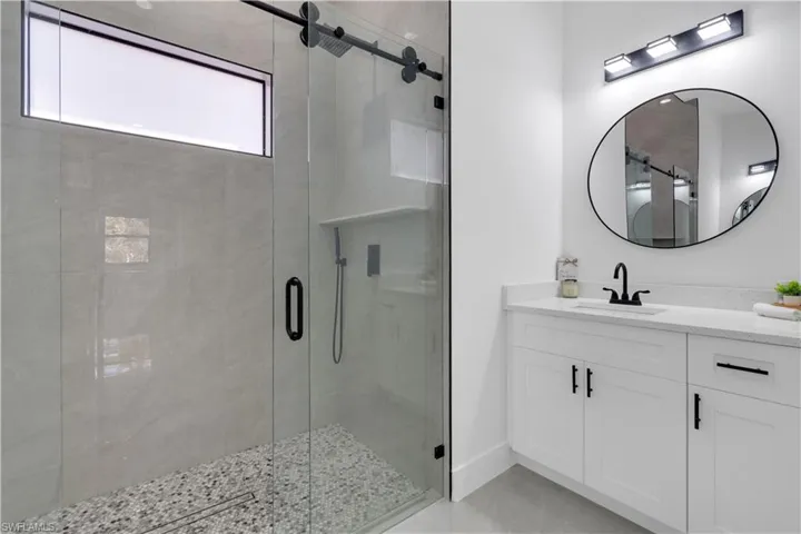 Full bathroom with vanity and a stall shower