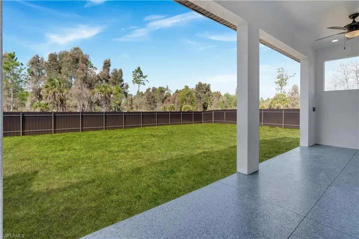 Fenced backyard with ceiling fan and a patio