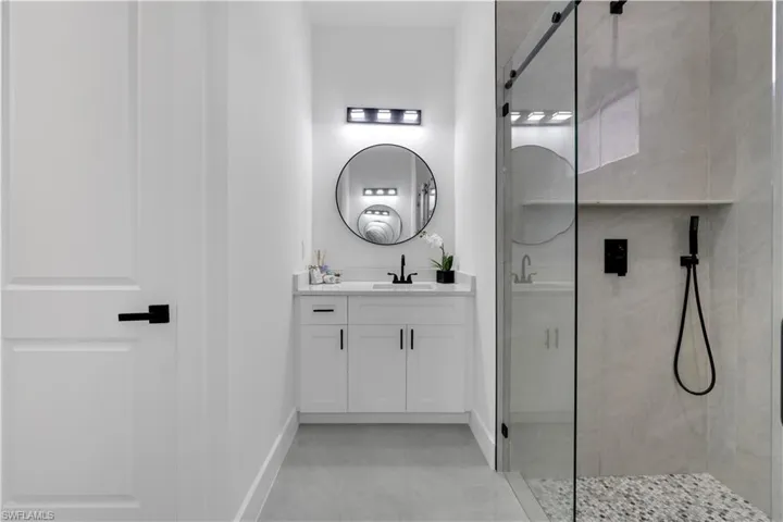 Bathroom featuring a tile shower and vanity