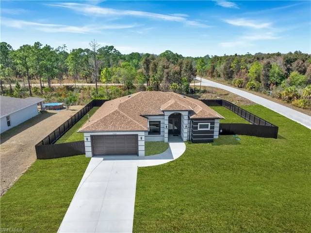 View of front of property with driveway, an attached garage, roof with shingles, and stucco siding