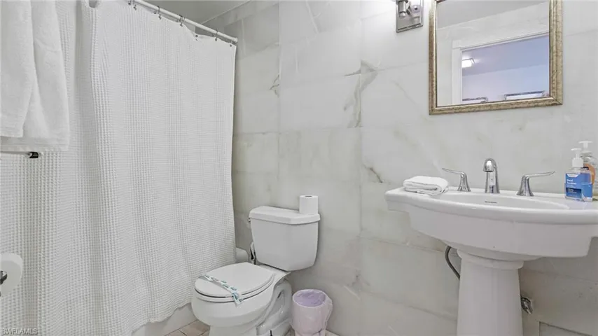Bathroom with tile walls and toilet