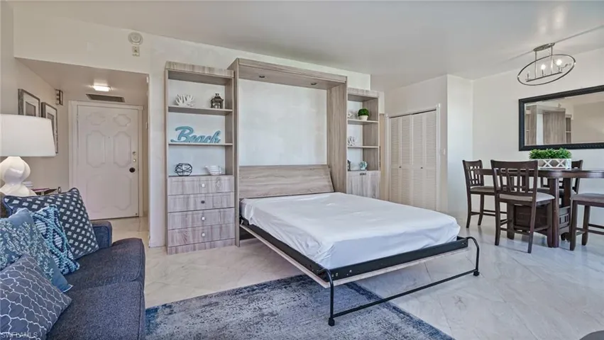 Bedroom with light tile patterned floors, an inviting chandelier, and a closet