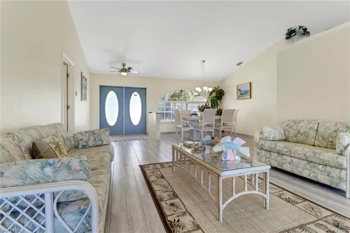 The living area features light-colored walls and flooring, with a vaulted ceiling