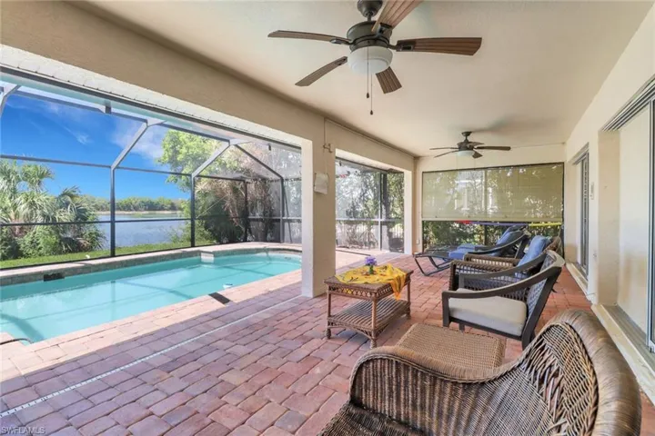 The property features a screened-in lanai with a swimming pool and a paved deck