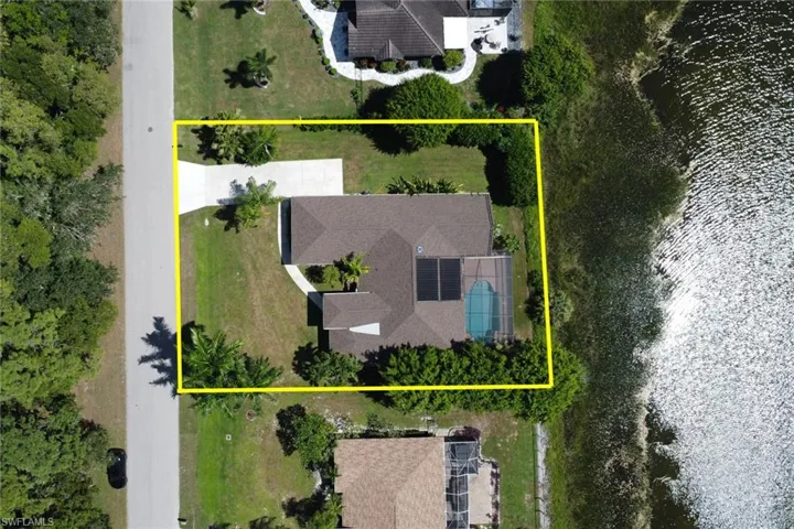 This property features a private swimming pool, a spacious driveway, and a well-maintained lawn with mature trees