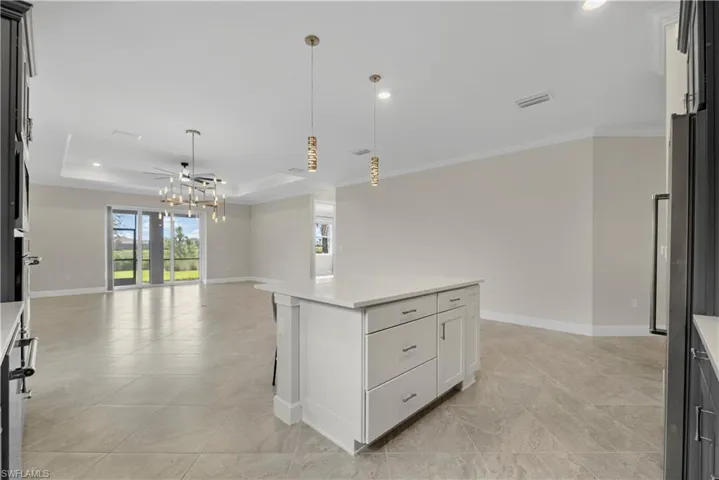 Central kitchen island with white cabinetry and a light-toned countertop