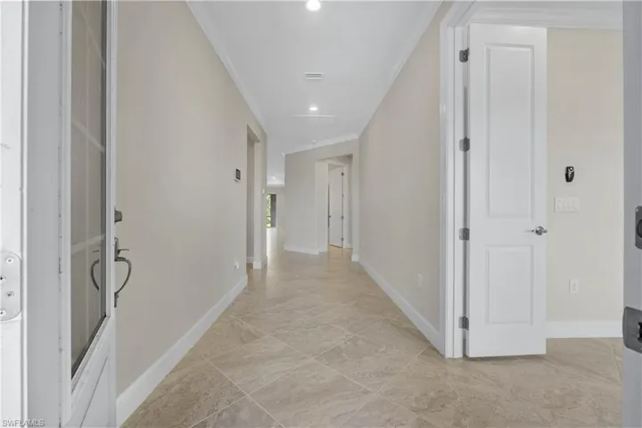 Tile flooring throughout, recessed lighting, and crown molding