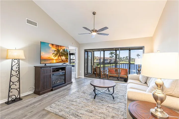 Living room featuring high vaulted ceiling, laminate engineered  floors, and a ceiling fan