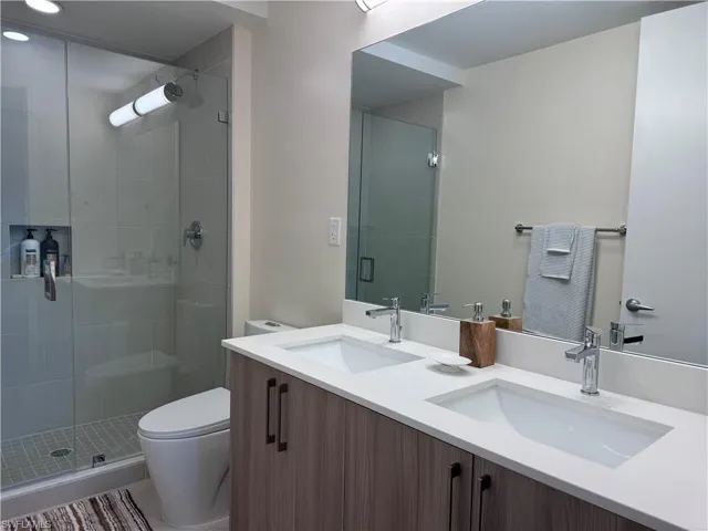 Bathroom with vanity, toilet, and a shower with door