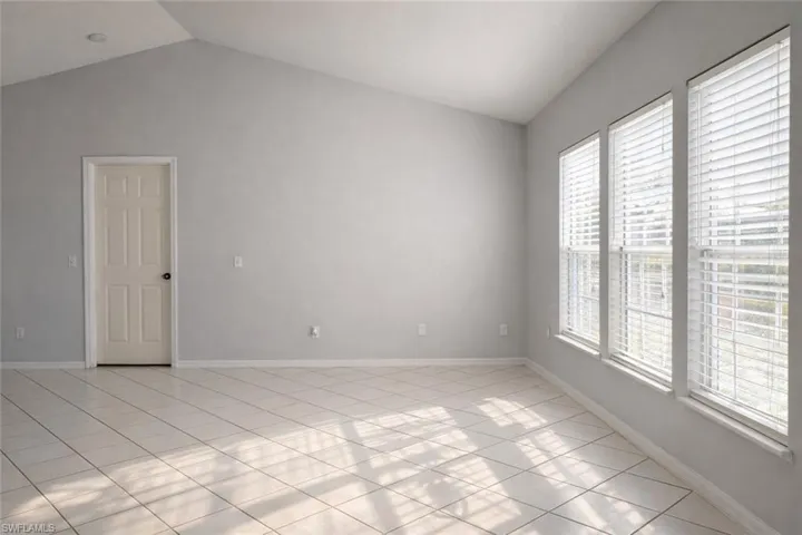 Spare room featuring vaulted ceiling and light tile patterned floors