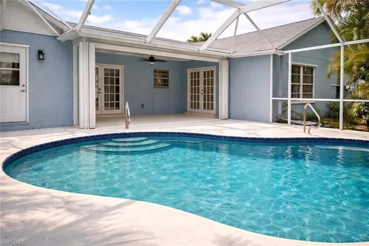 Outdoor pool with a sunroom, french doors, and glass enclosure