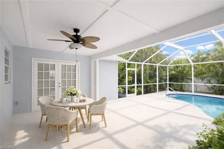 Swimming pool with a sunroom, a patio area, a lanai, and french doors
