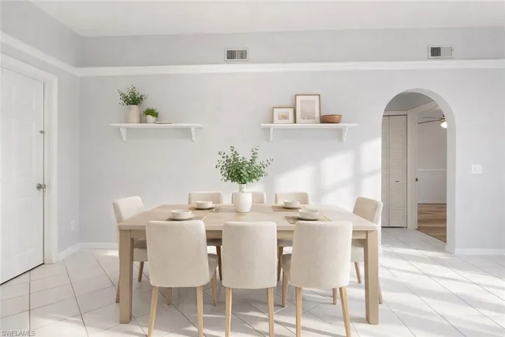 Dining area with arched walkways, light tile patterned floors, and ceiling fan