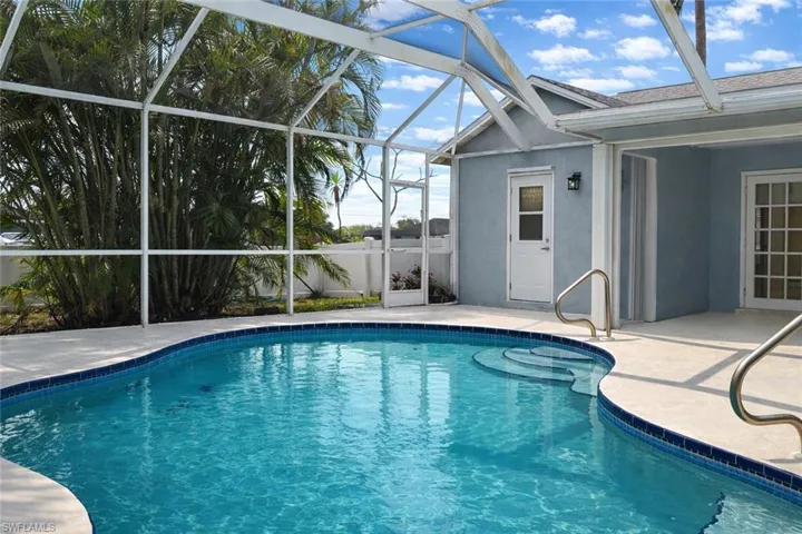 View of swimming pool featuring glass enclosure, a patio area, and a sunroom