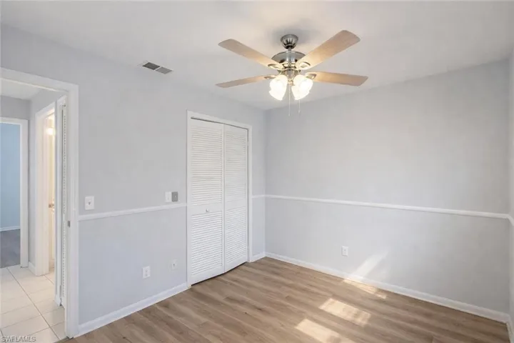 Unfurnished bedroom featuring light wood-type flooring, a closet, and a ceiling fan