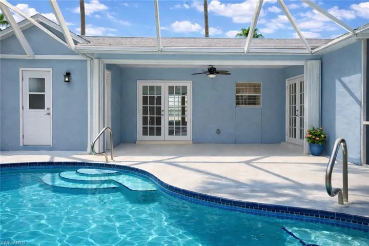 Swimming pool featuring french doors, a sunroom, a patio area, and a lanai