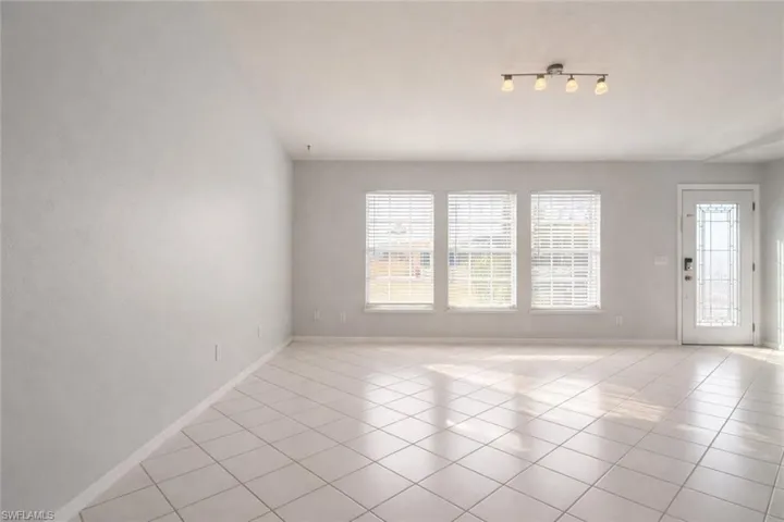 Spare room with light tile patterned flooring and baseboards