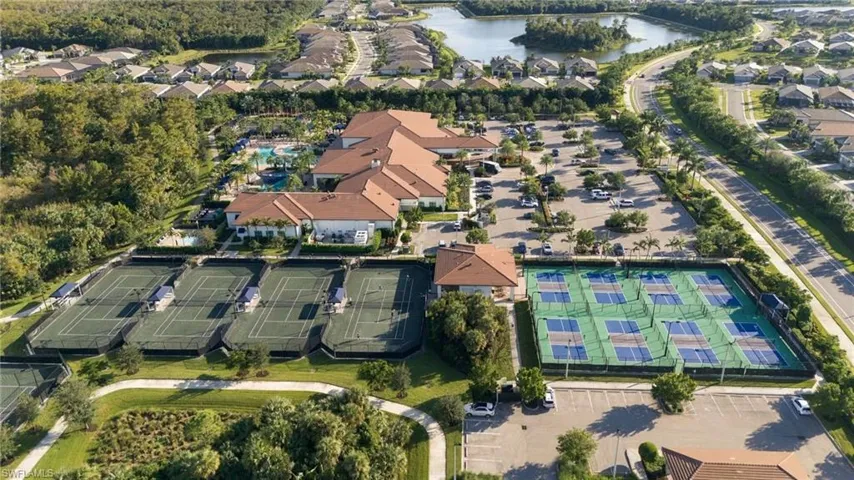 Aerial perspective of community recreational facilities featuring four tennis courts, four pickleball courts, a clubhouse, and an outdoor swimming pool
