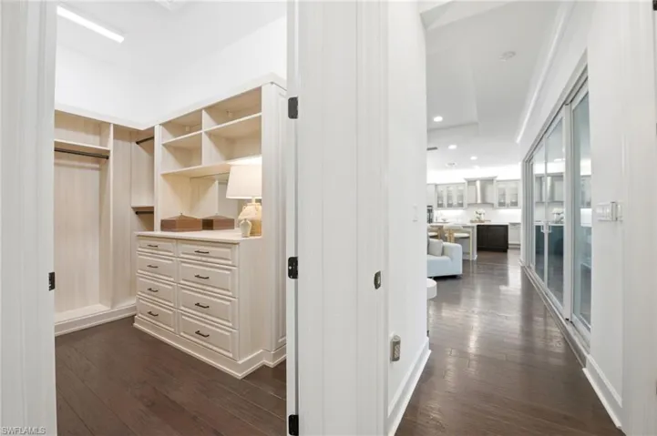 Custom closet with built-in cabinetry, shelving, and drawers, featuring wood-finish flooring and recessed lighting