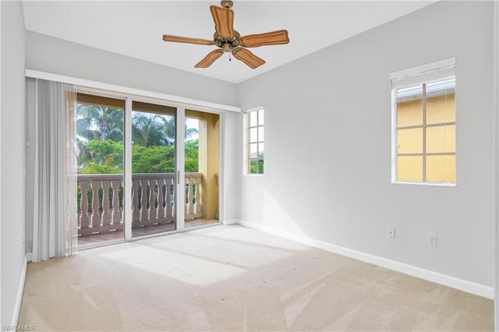 Large master suite includes a private balcony with sliding glass doors, ceiling fan and walk-in closet.