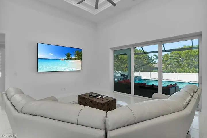 Living area featuring ceiling fan, a sunroom, and a high ceiling