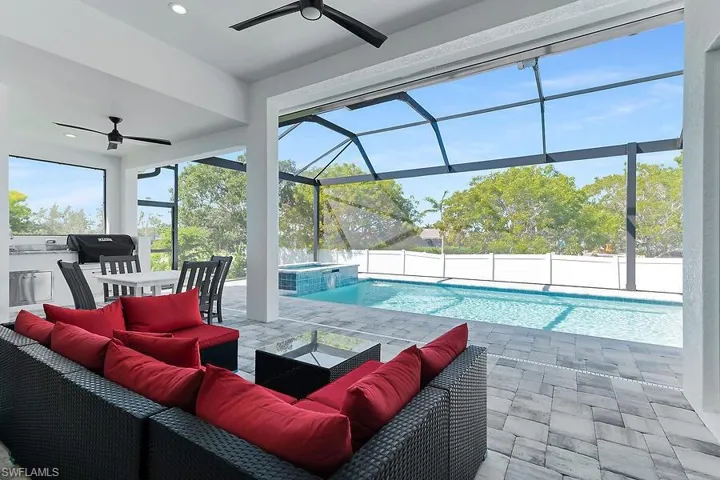 View of swimming pool featuring a ceiling fan, a sunroom, a patio, and glass enclosure