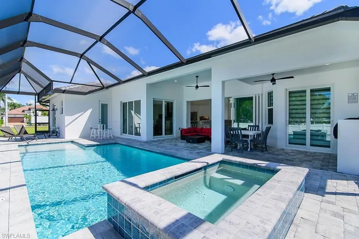 View of swimming pool with a sunroom, a patio area, an outdoor hangout area, and glass enclosure