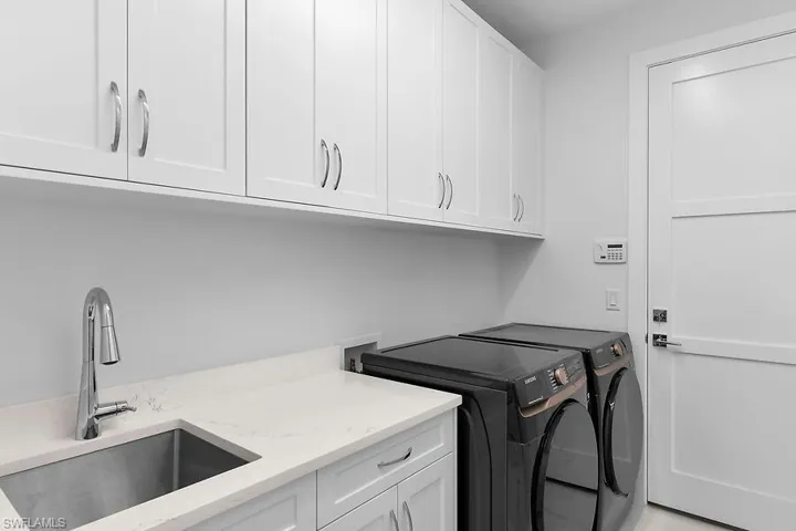 Laundry room with washer and clothes dryer and cabinet space