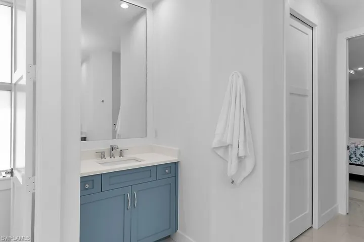 Ensuite bathroom with vanity, recessed lighting, and light tile patterned floors