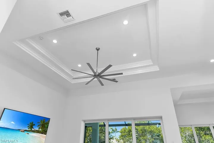 Detailed view of a tray ceiling, recessed lighting, and ornamental molding