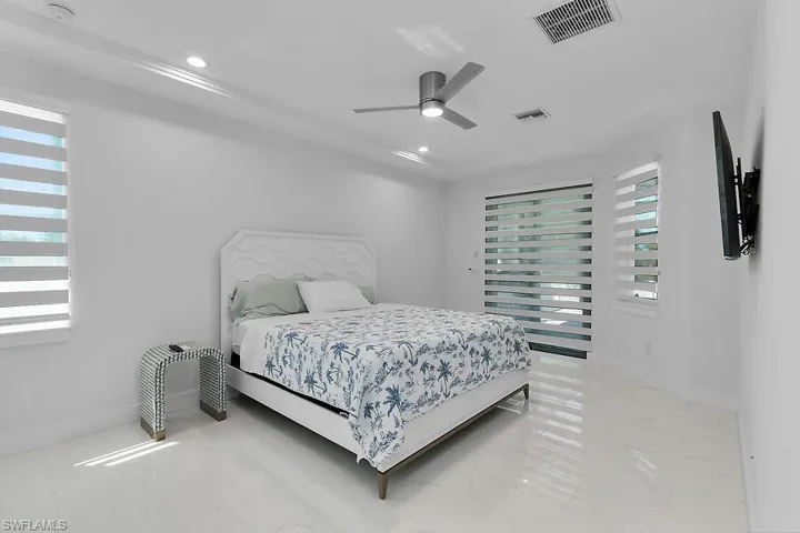 Primary bedroom with ceiling fan and recessed lighting
