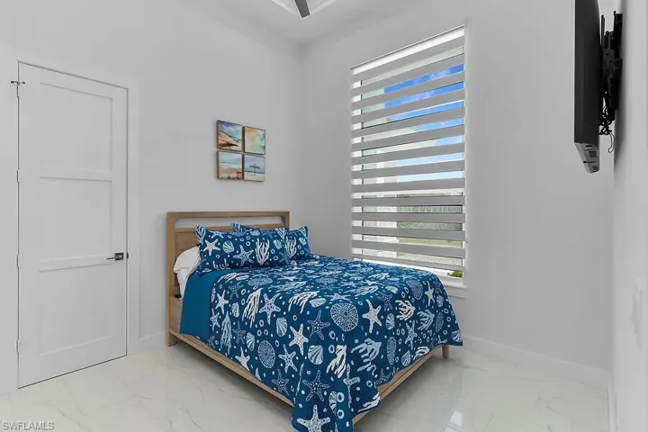 Bedroom #3 with light marble finish floors and baseboards