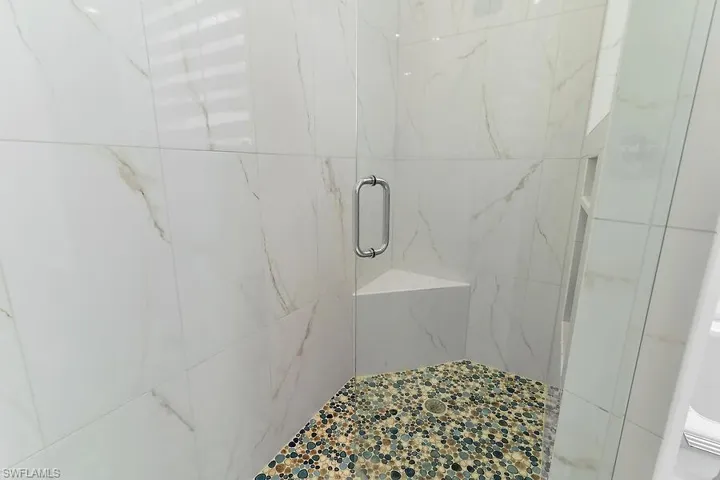 Full bath featuring a marble finish shower