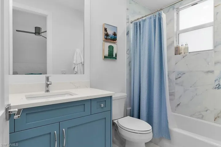 Guest bathroom #1with shower / bathtub combination with curtain and vanity