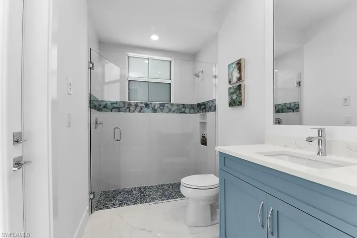 Pool bath with vanity, a stall shower, marble finish floors, and recessed lighting