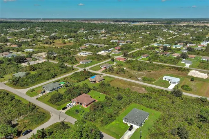 Aerial view of property and surrounding area featuring nearby suburban area