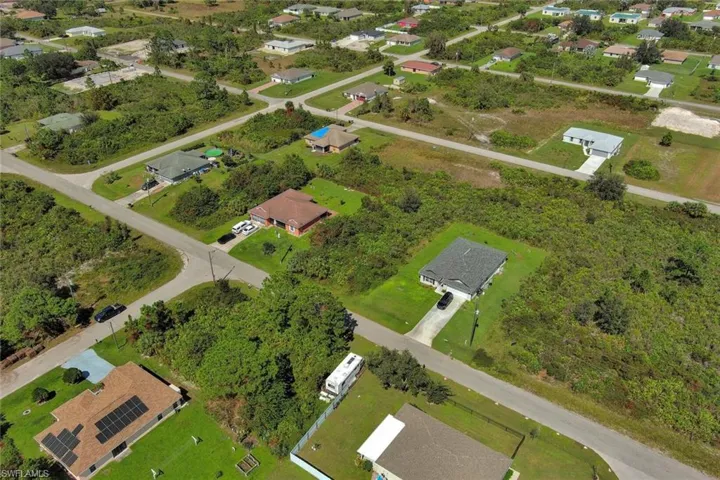 Aerial view of property and surrounding area with nearby suburban area