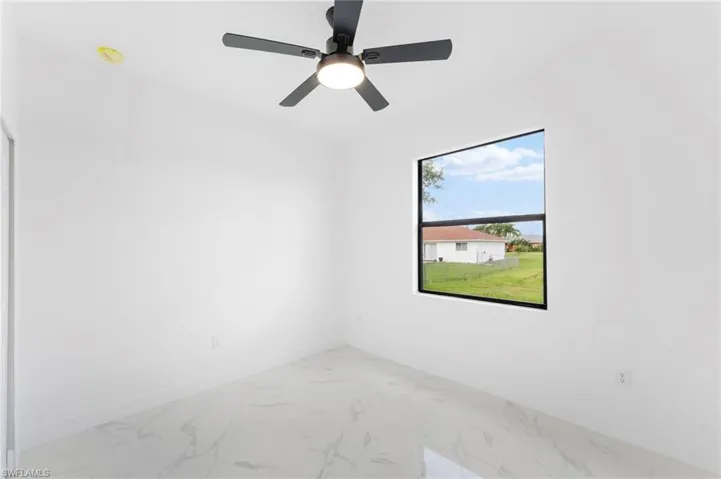 Empty room with marble finish floors and ceiling fan