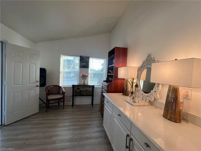 Living area with dark wood-style floors and vaulted ceiling