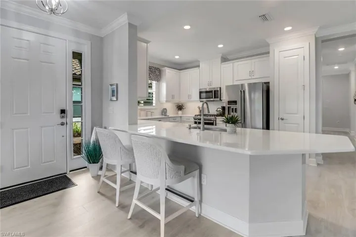 Kitchen with a sink, visible vents, white cabinets, light countertops, and appliances with stainless steel finishes