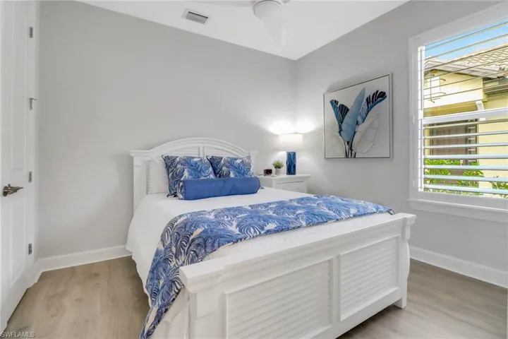 Bedroom with wood finished floors, visible vents, and baseboards