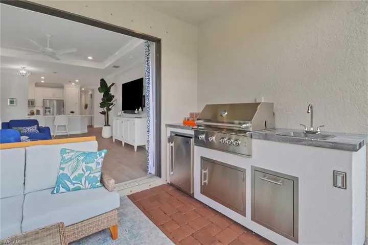 Outdoor kitchen with grill, refrigerator and sink