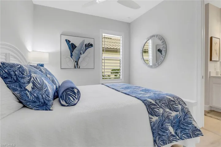 Bedroom featuring ensuite bath and a ceiling fan
