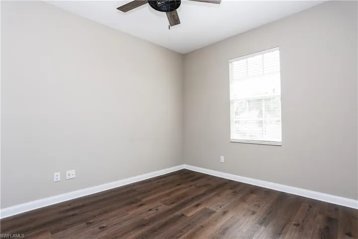 Spare room featuring dark wood finished floors and a ceiling fan