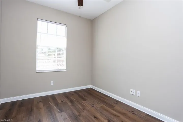 Unfurnished room with dark wood-style floors and a ceiling fan