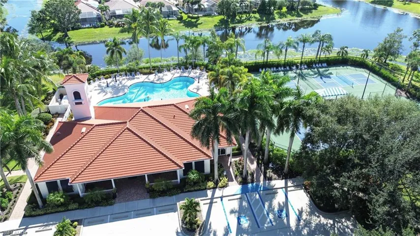 Drone / aerial view of a nearby body of water and a pool