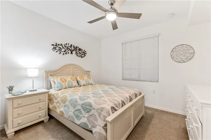 Carpeted bedroom featuring ceiling fan